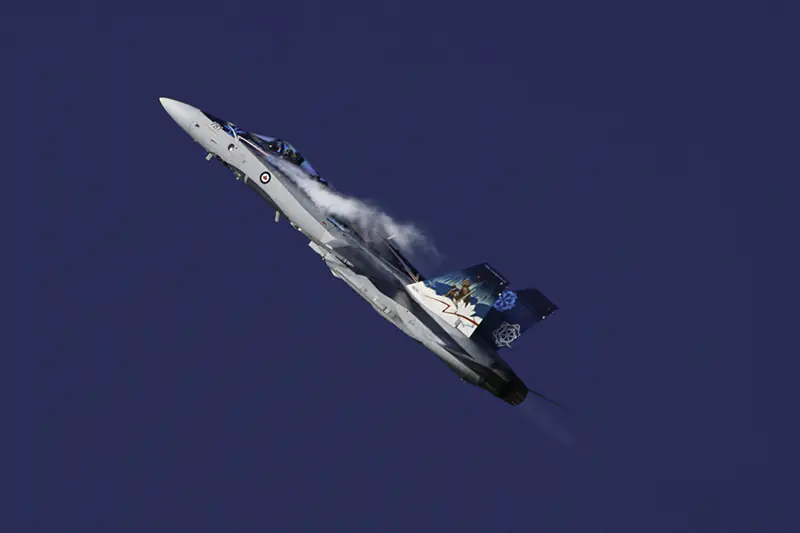 A CF-18 Hornet breaks the sound barrier as it rockets higher-and-higher into the deep blue sky.   Photo by Jeffrey Meyer.