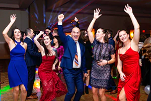 Event attendees celebrate with music, dancing and jumping with hands and laser lights in the air.   Photo by Jeffrey Meyer.   