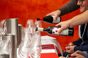 Servers begin to serve red wine for a taste testing session.   Photo by Jeffrey Meyer.