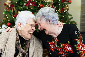 Two long-time friends share a loving embrace during a lifetime celebration event.  Photo by Jeffrey Meyer.