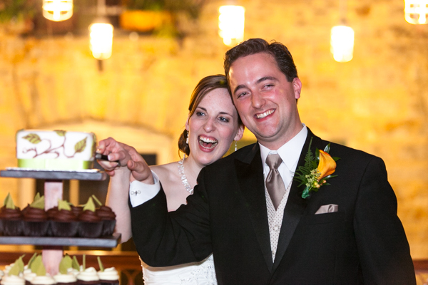 a bride and groom cut into their cake with excitement